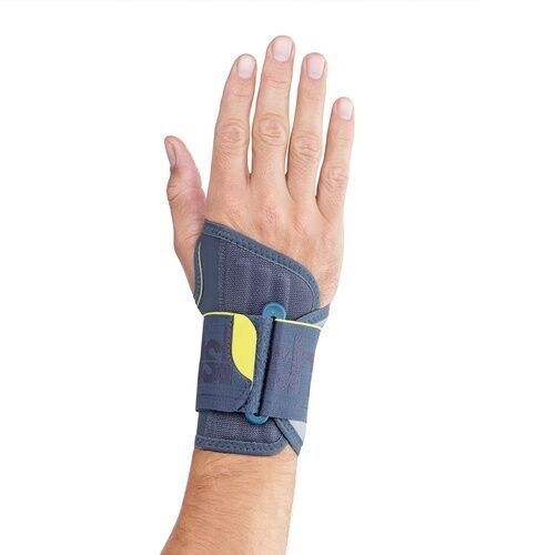 Handgelenkbandage am Handgelenk. Grau mit gelben Akzenten. Klettverschluss. Teilweise am Hand getragen.