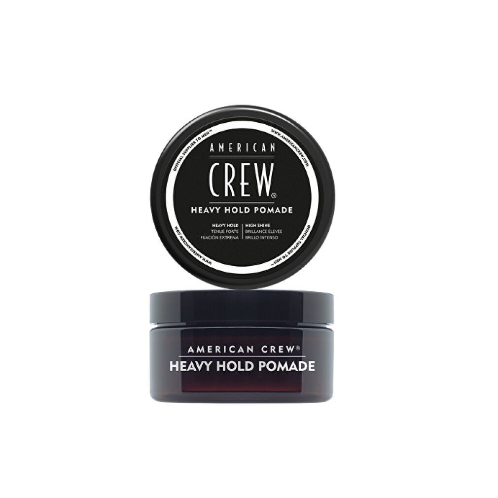 Zwei schwarze Tiegel American Crew Heavy Hold Pomade. Der obere Deckel zeigt Produktnamen und Details. Der untere Tiegel ist geöffnet.