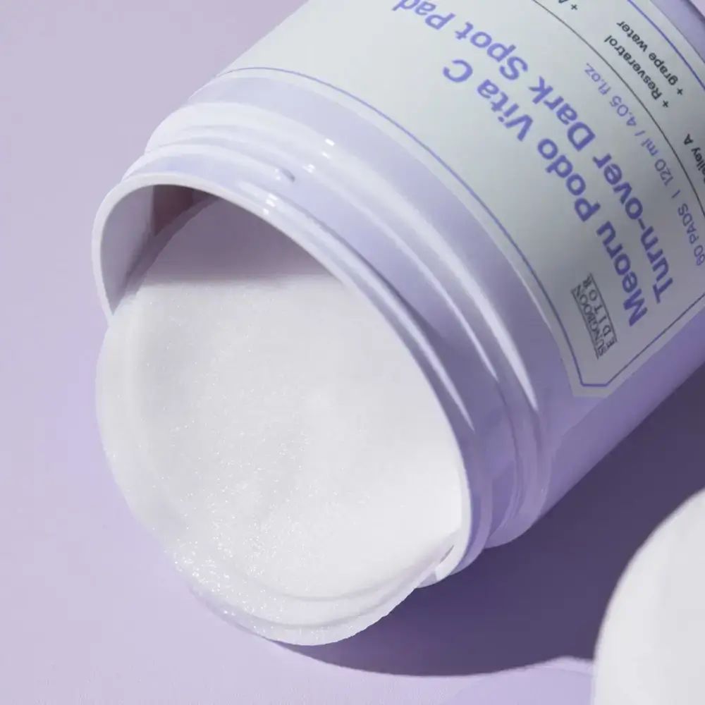 Geöffnetes Produktglas mit Pads. Aufschrift: Meoru Podo Vita C Turn-over Dark Spot Pad. Pads sichtbar.