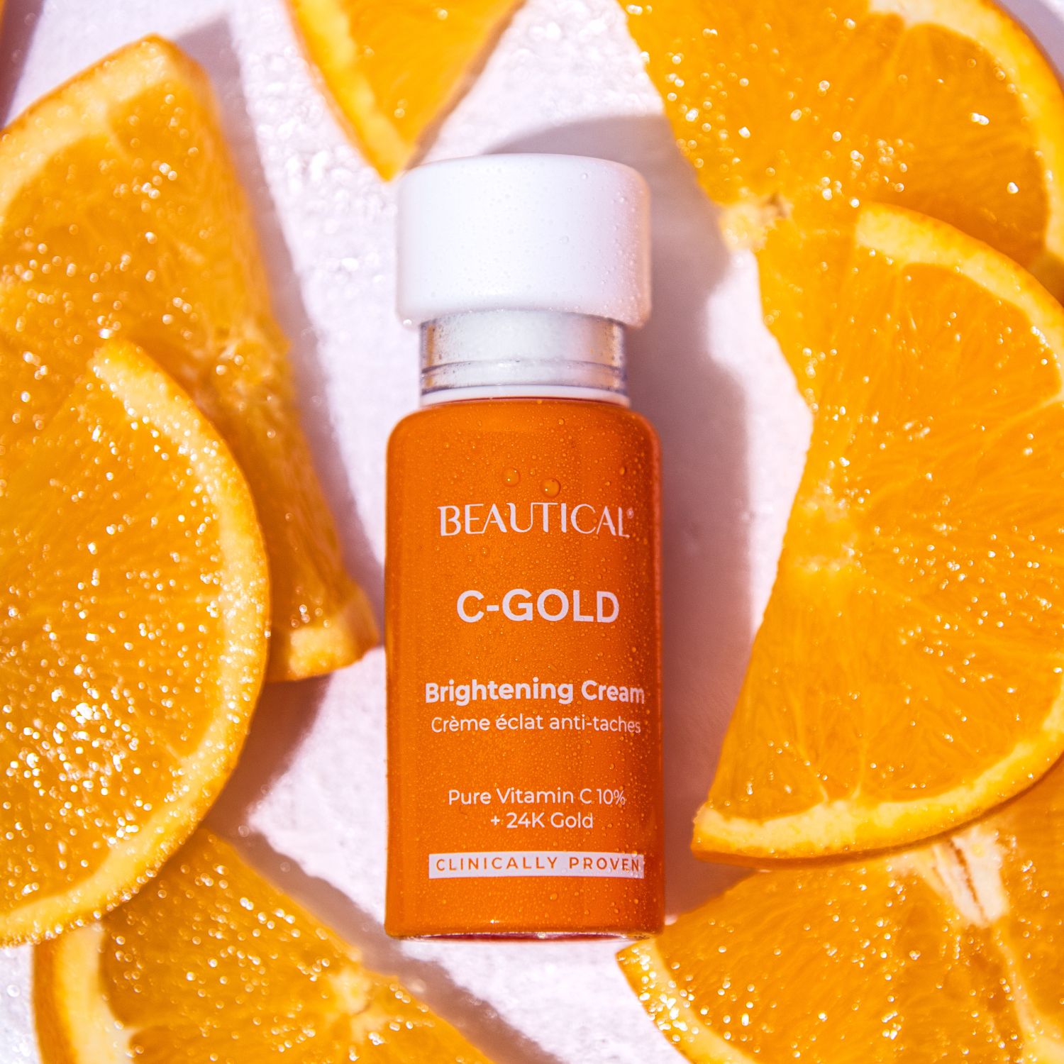 Produktflasche und Orangenscheiben. Aufschrift: BEAUTICAL C-GOLD Brightening Cream.