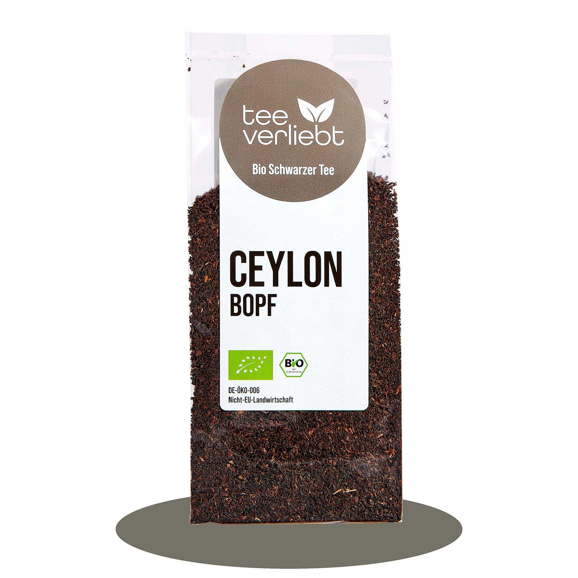 Transparente Verpackung mit losem Tee. Aufdruck: "tee verliebt", "Bio Schwarzer Tee", "CEYLON BOPF", Bio-Siegel.