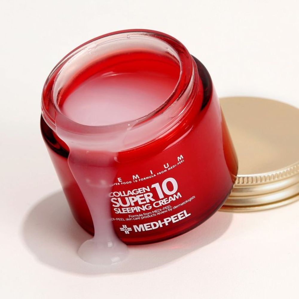 Offener roter Glascremetiegel mit goldenem Deckel, zeigt weiße Creme, die über den Rand fließt.