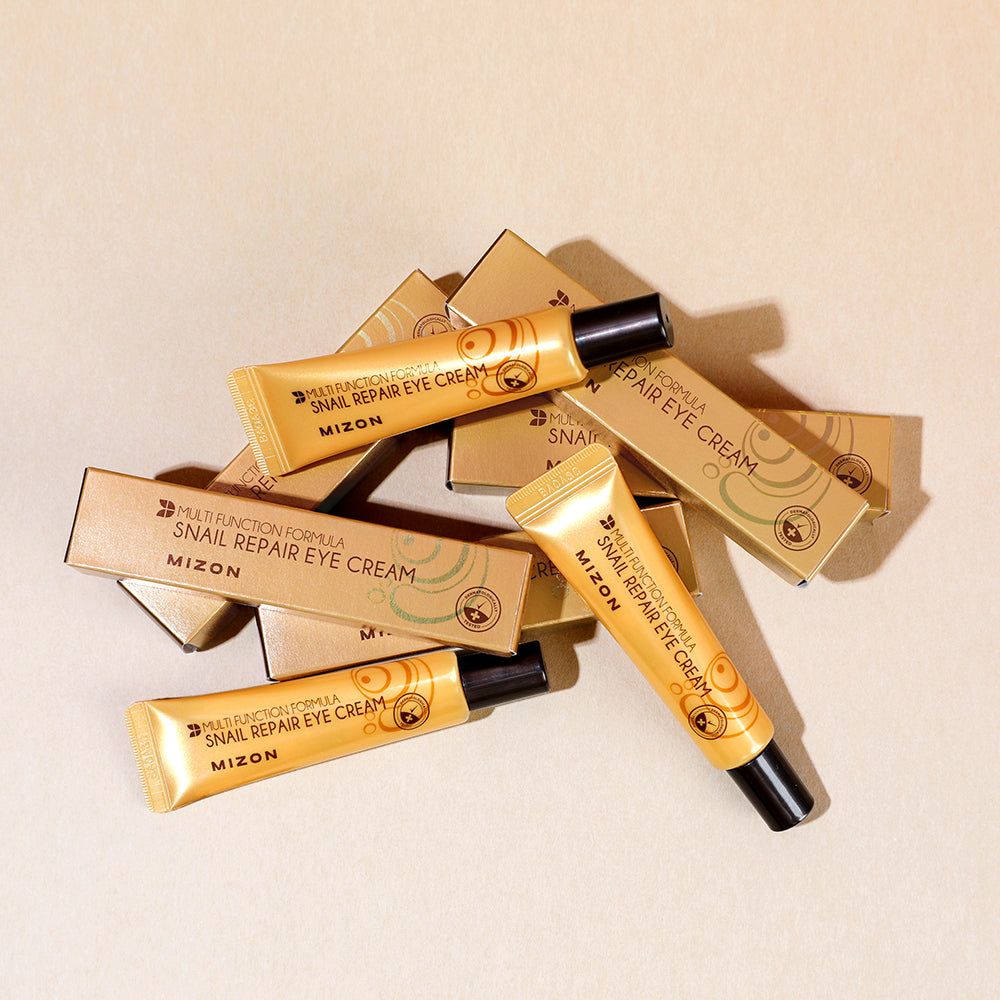 Mehrere Tuben und Schachteln. Aufschrift: Mizon Snail Repair Eye Cream.