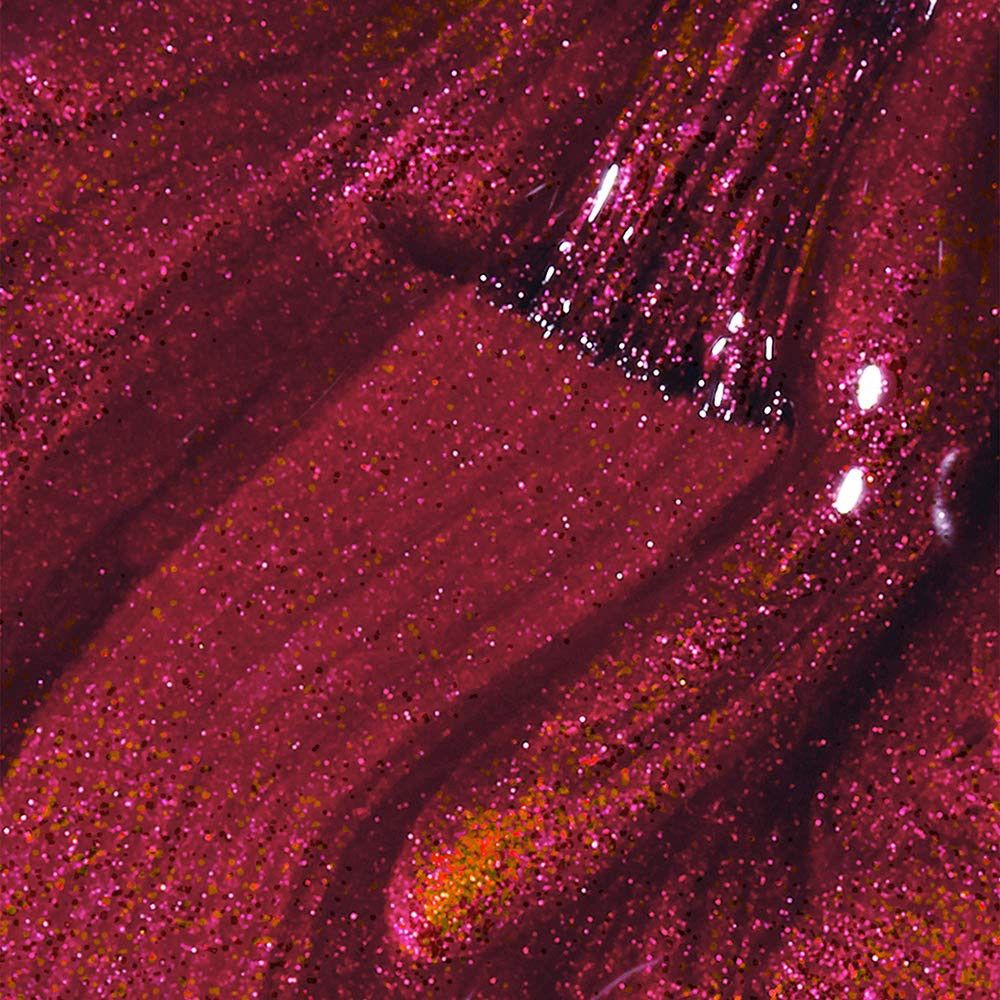 Nagellack-Farbmuster mit Pinsel. Dunkelroter Lack mit Glitzerpartikeln. Pinselspuren sichtbar.