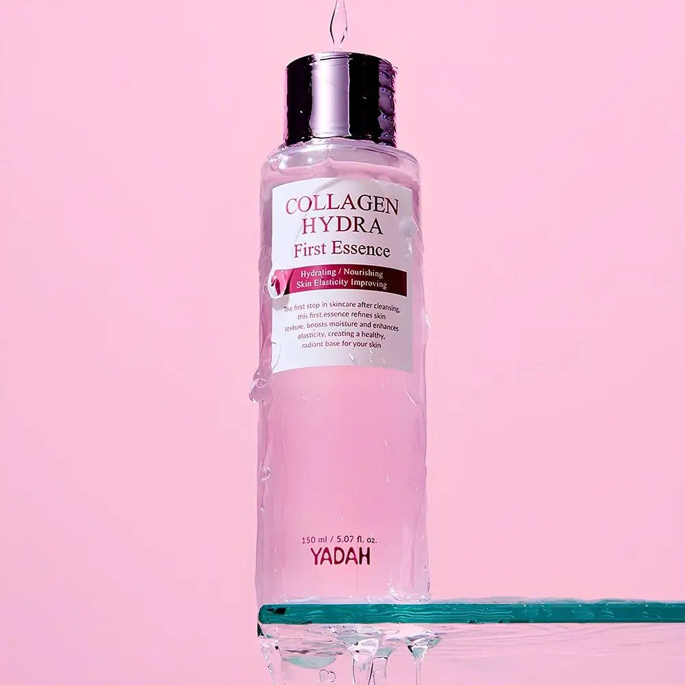 Transparente Flasche mit rosa Flüssigkeit. Aufschrift: Collagen Hydra First Essence. Tropfen fallen von der Flasche.