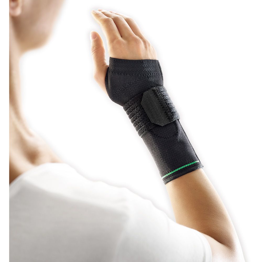 Seitenansicht einer schwarzen Handgelenkbandage mit grünen Akzenten an einem Arm.