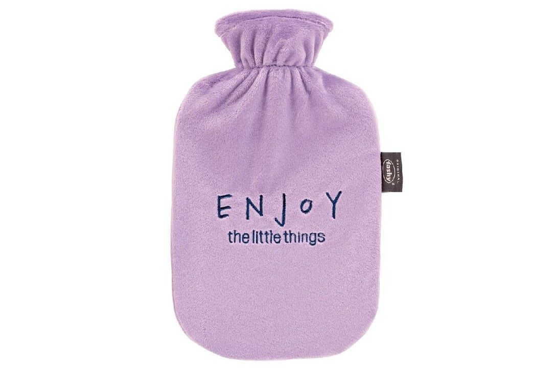 Fashy Wärmflasche Enjoy. Fliederfarbene Wärmflasche mit Stoffbezug. Aufschrift "ENJOY the little things".