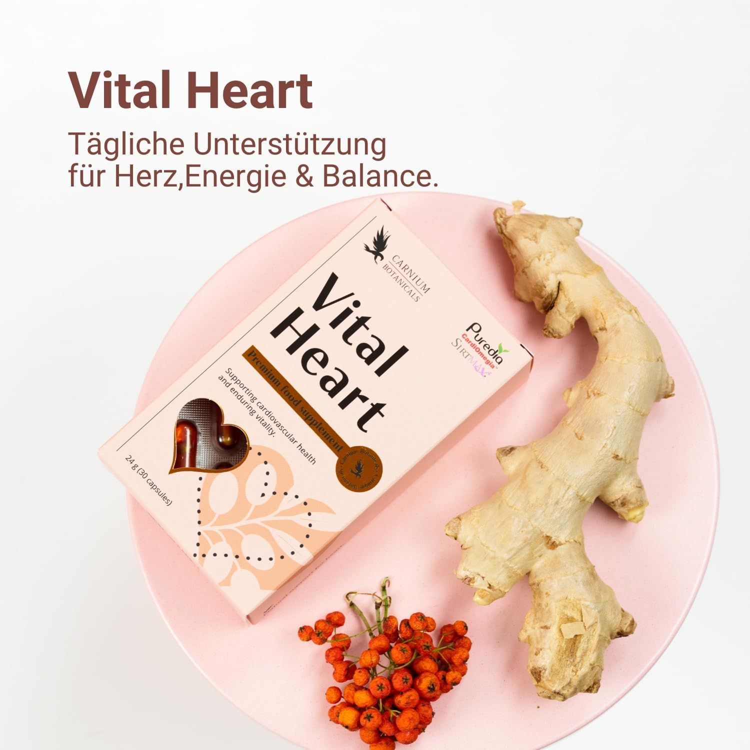 Rosa Schachtel "Vital Heart" auf einem rosa Teller mit Ingwer und Beeren.