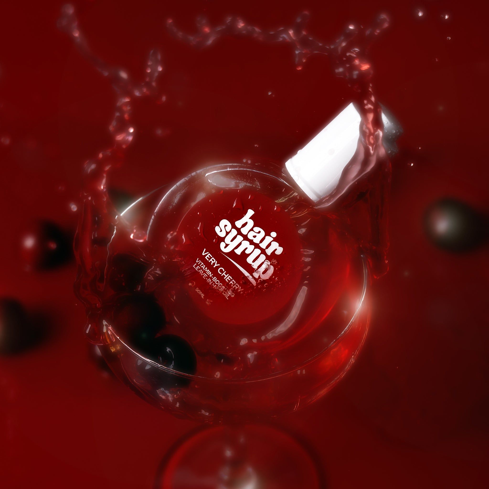 Runde Flasche mit roter Flüssigkeit, umgeben von Flüssigkeitsspritzern. Weißer Deckel, rotes Etikett.