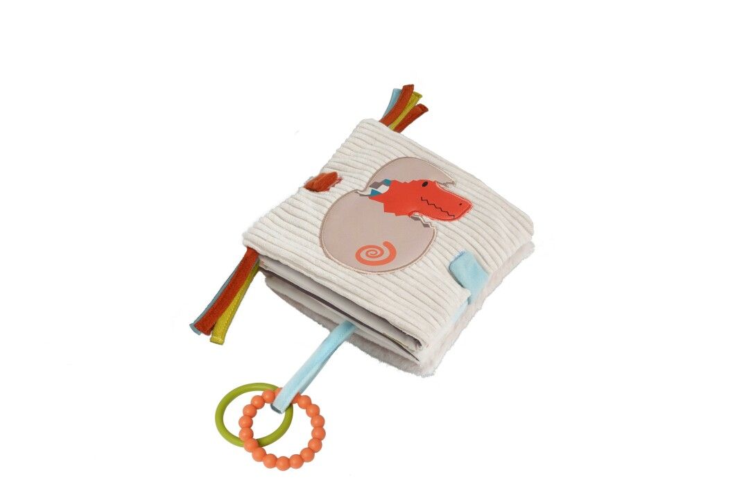Quadratisches Stoffbuch mit Dino im Ei-Motiv. Bunte Bänder und Ringe zum Greifen. Flauschiges Material.