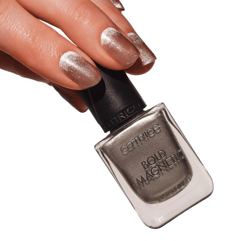 Hand mit lackierten Nägeln und Nagellackflasche. Aufschrift: Catrice, Bold Magnetic, Nail Polish. Farbtöne: Silber, Grau.