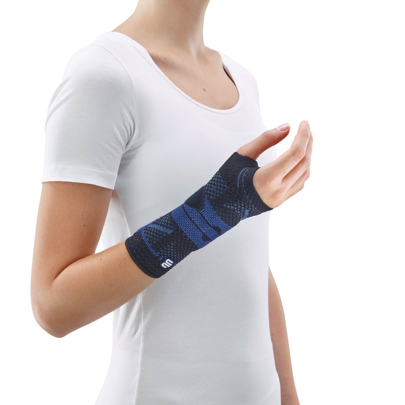 Handgelenkbandage MANUTRAIN SCHWARZ RECHTS 2. Grau-blaues Gestrick, am Handgelenk getragen. Frau mit weißem T-Shirt.
