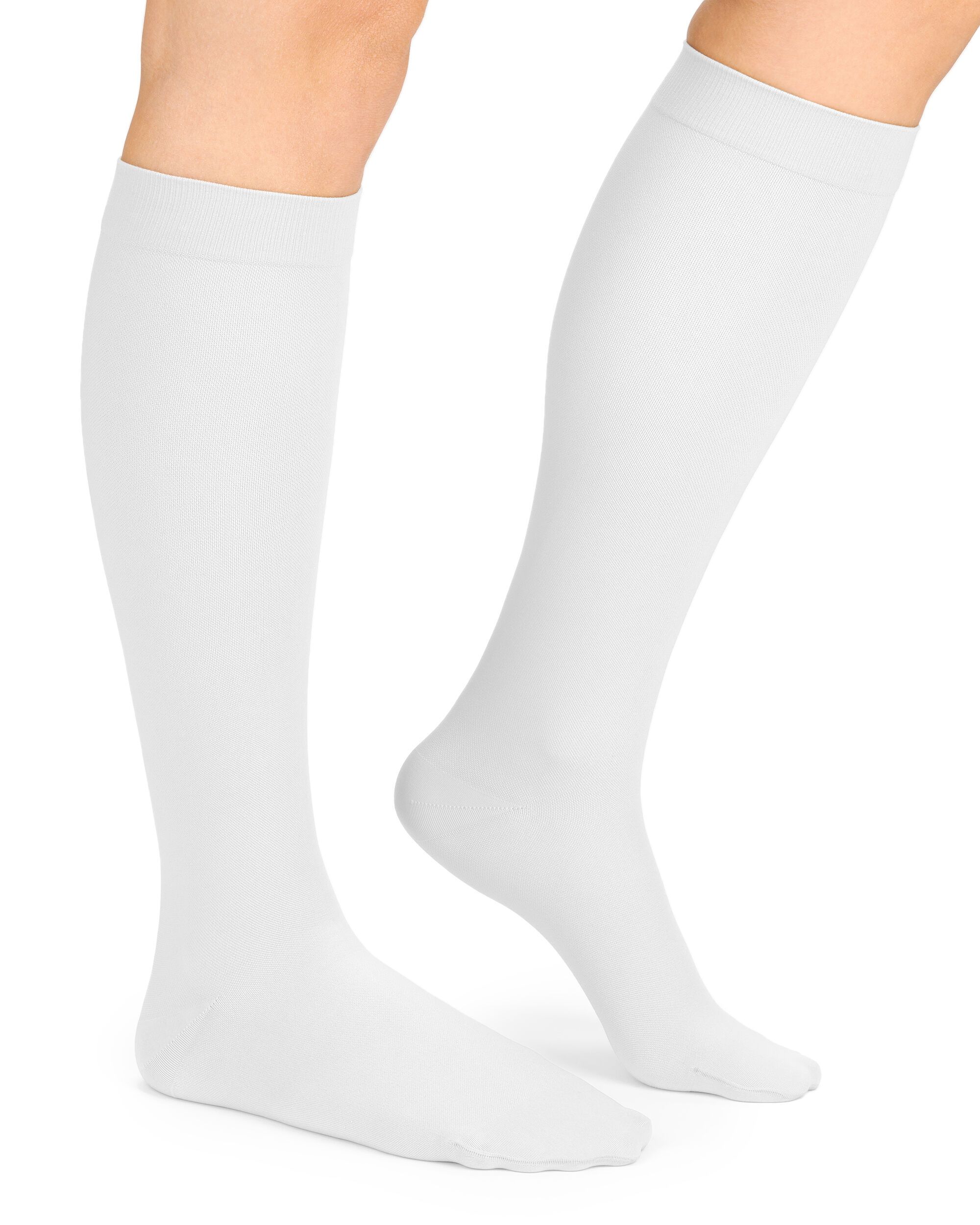 Weiße Kompressions-Kniestrümpfe an Beinen. Glatter Stoff, bis zum Knie reichend. Zehen- und Fersenbereich erkennbar.