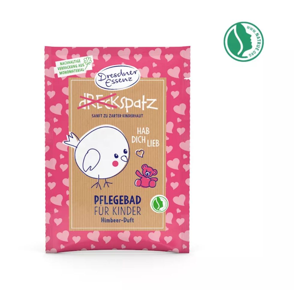Rosa Pflegebad-Verpackung mit Herzmuster, Vogel-Illustration und Text: 'Pflegebad für Kinder'. Naturkosmetik-Siegel.