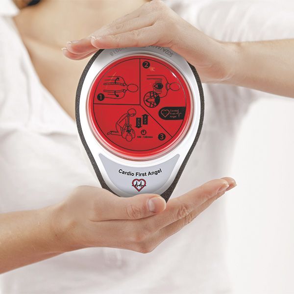 Cardio First Angel, gehalten von Händen. Roter Knopf mit Anweisungen, weißer Rahmen, grauer Schaumstoff. Text: Cardio First Angel.