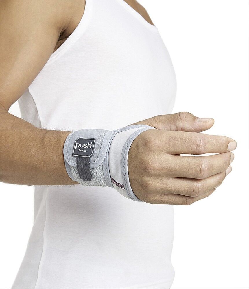 Person trägt eine graue Handgelenkbandage. Das Push-Logo ist sichtbar. Die Bandage bedeckt das Handgelenk.
