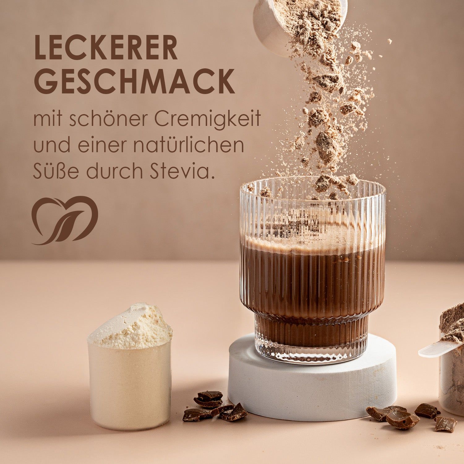 Glas mit Protein-Shake. Pulver wird in das Glas gegossen. Daneben ein Messbecher mit Pulver und Schokoladenstücke.