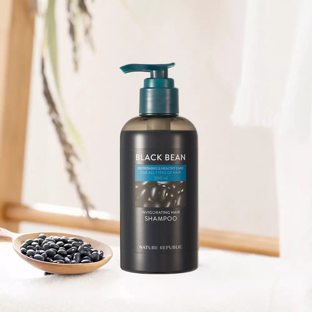 Schwarze Shampoo-Flasche mit Pumpe. Text: Black Bean, Invigorating Hair Shampoo, Nature Republic. Bohnen und Holzlöffel.