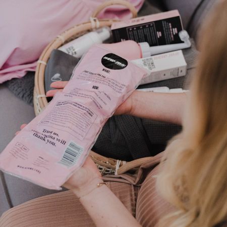 Rosa Kühlbinde in Folienverpackung. Text: "Trust us, vagina will thank you.". Weitere Produkte im Korb.