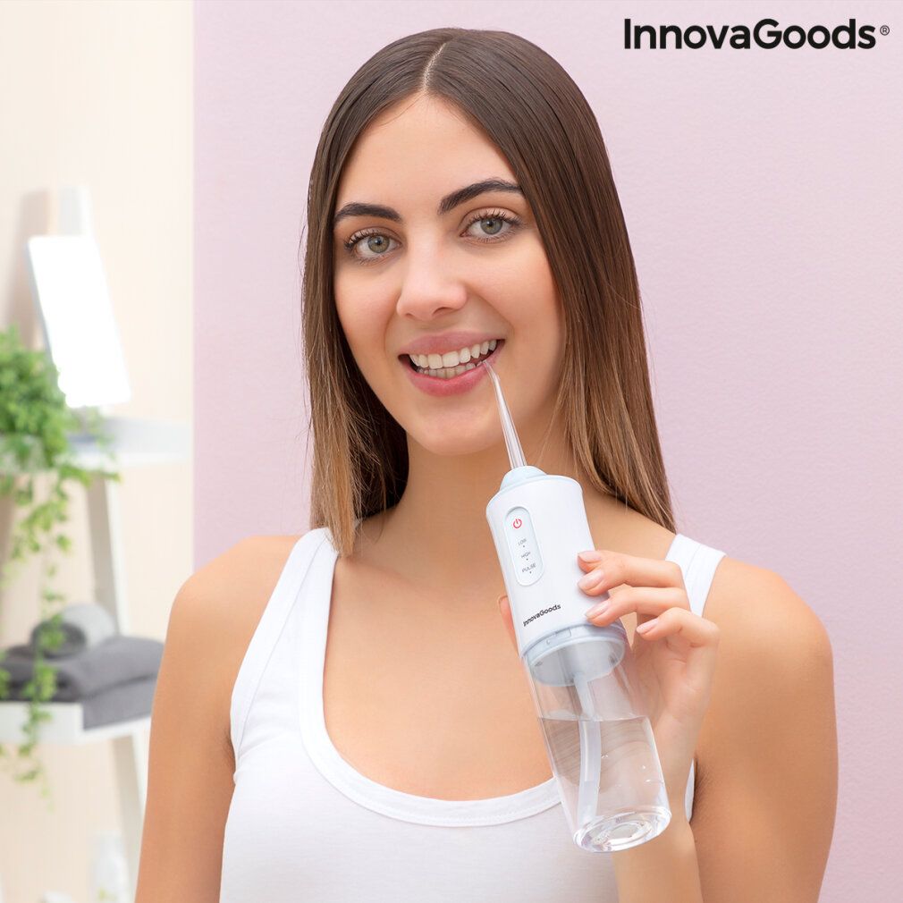 Tragbare Munddusche, weiß mit transparentem Behälter. Frau benutzt das Gerät. InnovaGoods Logo.