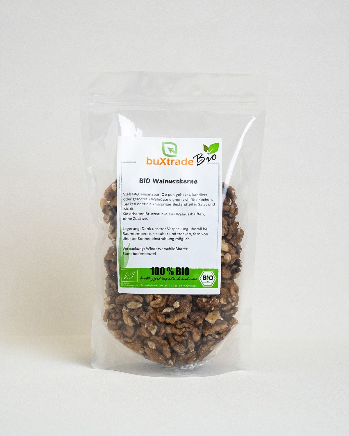 Transparente Verpackung mit buXtrade Bio Walnusskernen. Etikett mit Produktinformationen und Bio-Siegel.