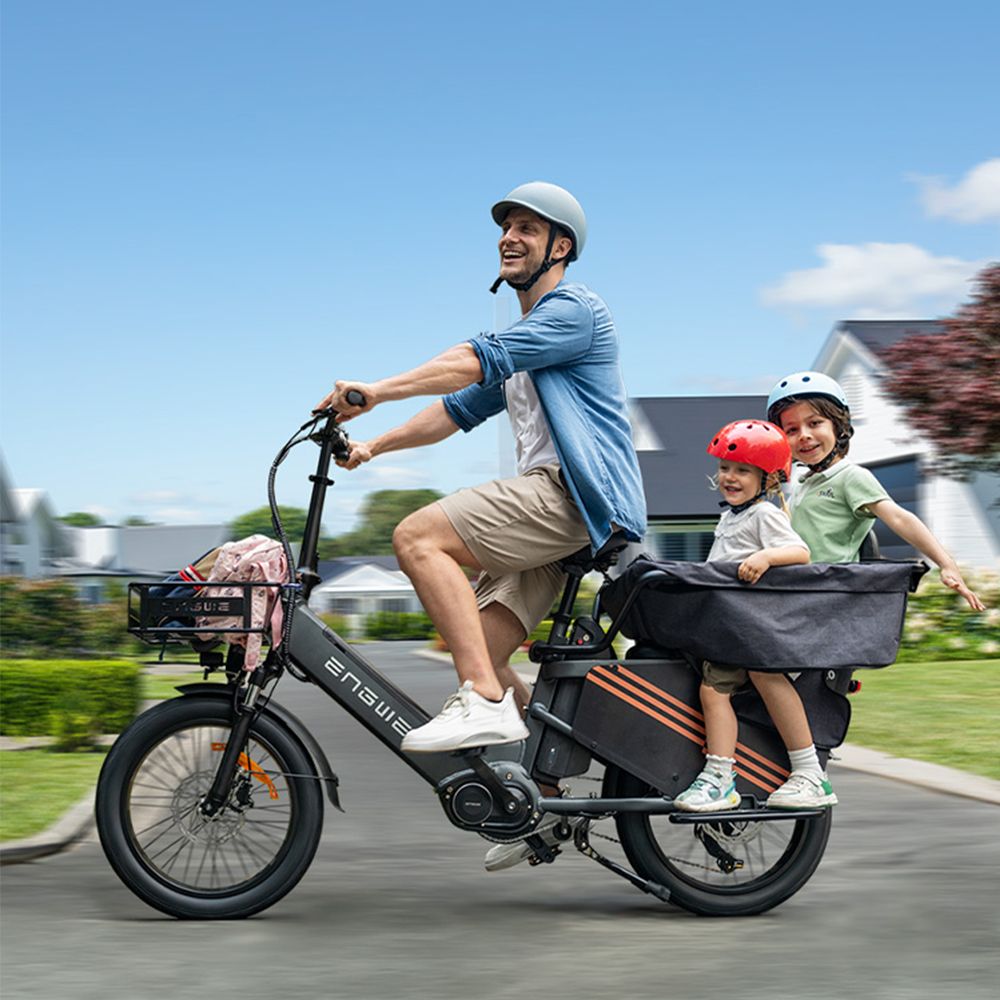 Mann fährt E-Bike mit zwei Kindern im Gepäckträger. Marke ENGWE. Schwarzes E-Bike.