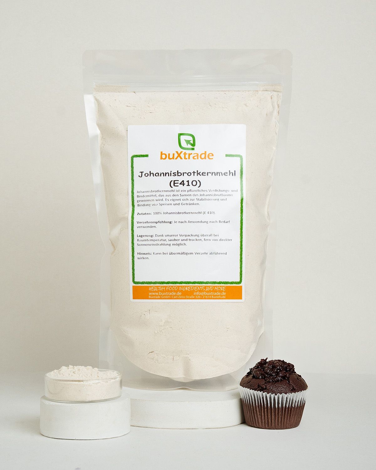 Verpackung mit Johannisbrotkernmehl, Muffin und einem runden Gebäck.