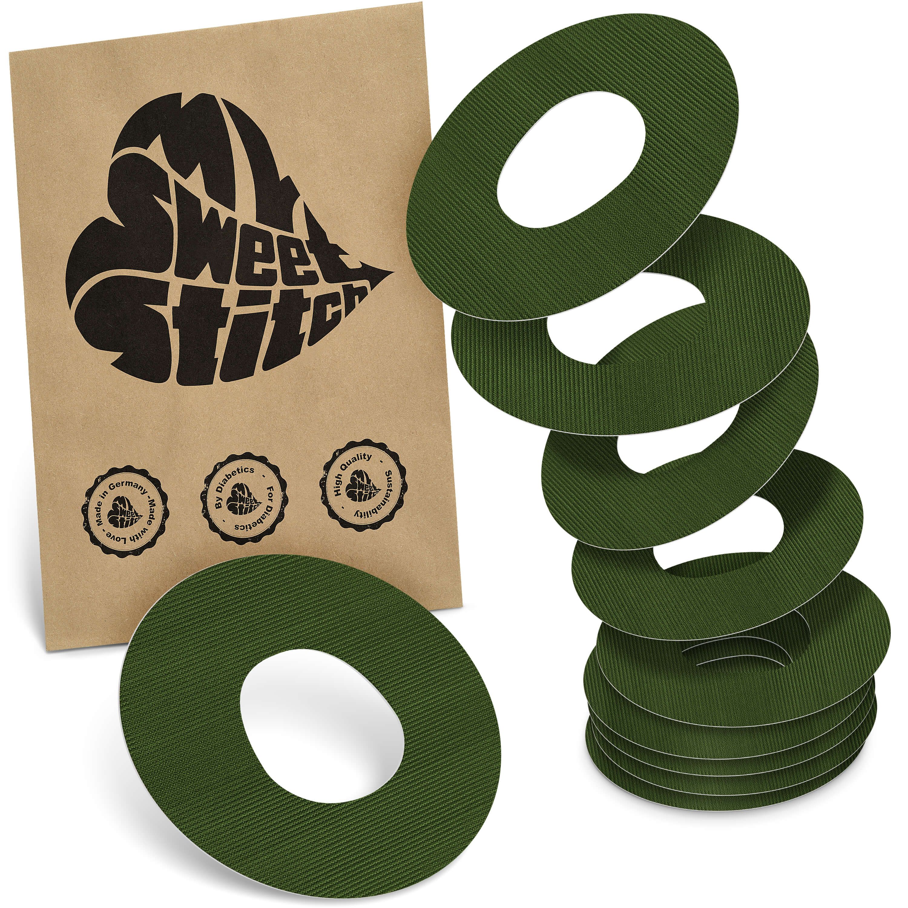 Braune Verpackung mit Logo und grünen, ringförmigen Pflastern. Mehrere Pflaster sind gestapelt. Auf der Verpackung sind Qualitätssiegel abgebildet.