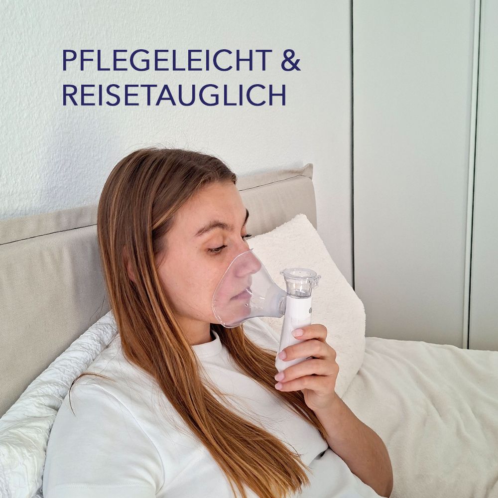 Eine Frau mit einer Erwachsenenmaske, die ein Inhalationsgerät benutzt. Text: PFLEGELEICHT & REISETAUGLICH.
