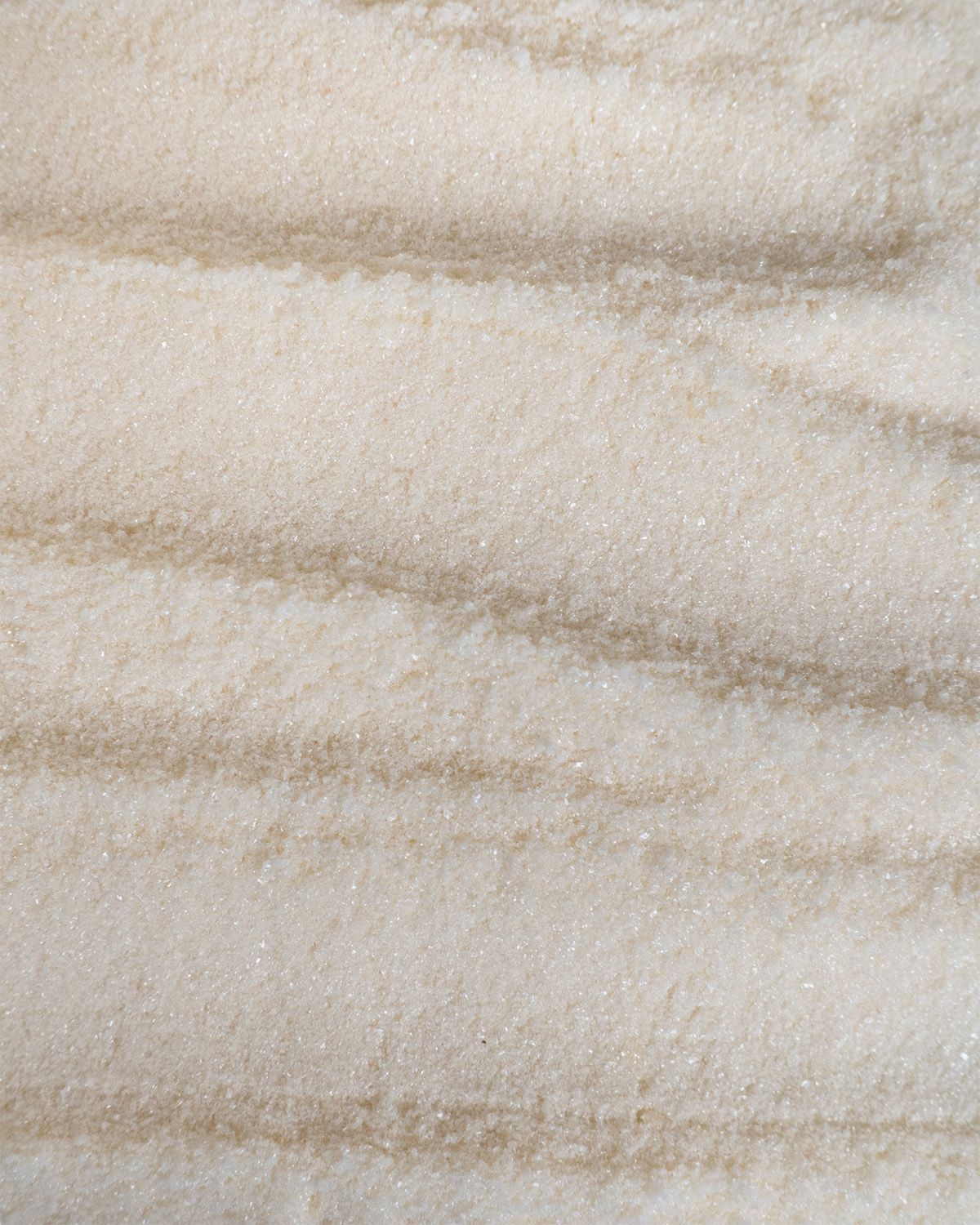 Nahaufnahme von cremefarbenem Pulver mit braunen Streifen. Texturähnliches Muster.