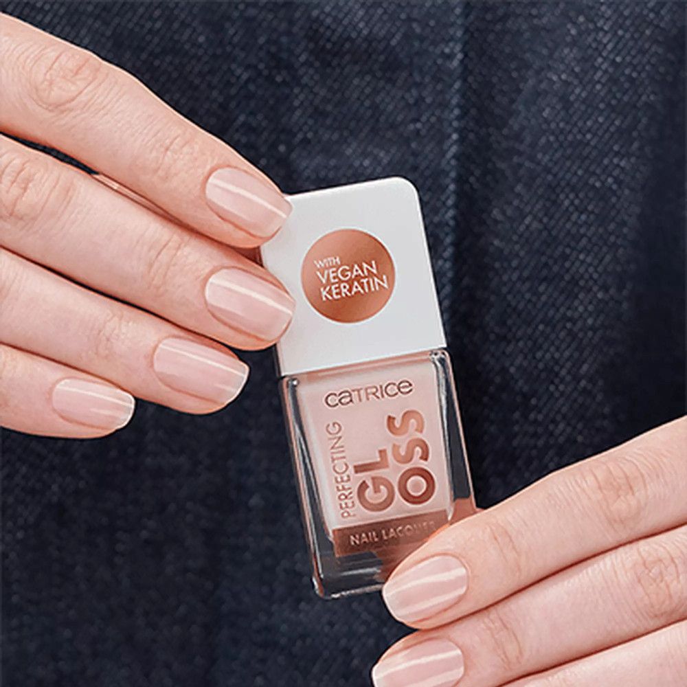 Hände halten eine Nagellackflasche. Auf der Flasche steht "Catrice Perfecting Gloss Nail Lacquer".