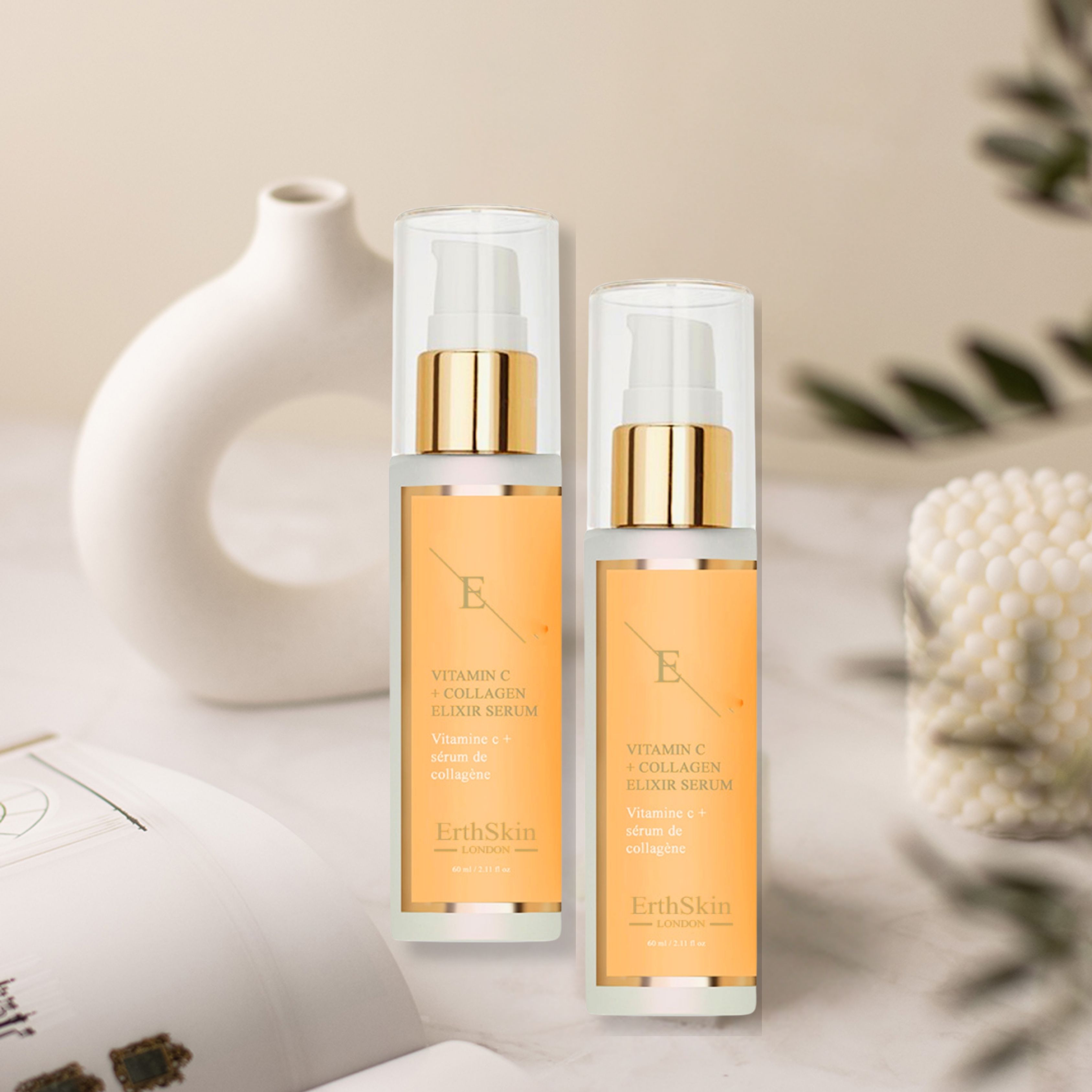 Zwei Serumflaschen mit goldfarbenen Pumpköpfen und Etiketten. Aufschrift: Vitamin C + Kollagen Elixir Serum. Marke: ErthSkin London.