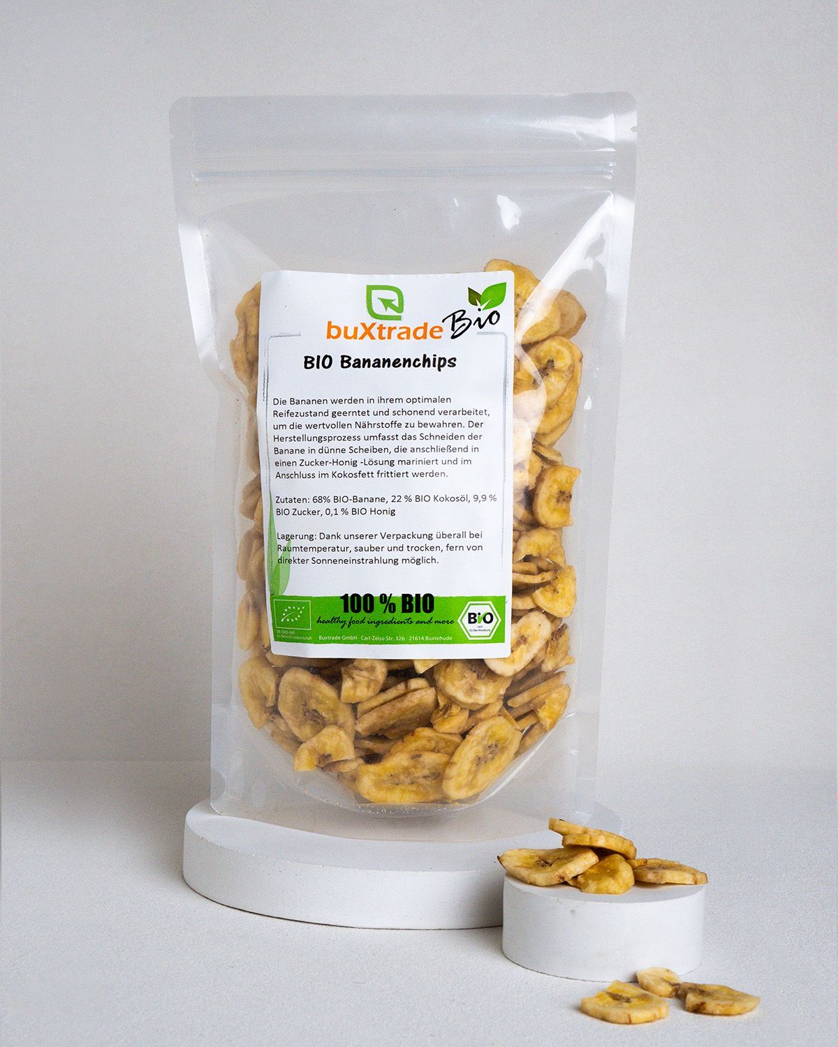Klarsichtbeutel mit Bio Bananenchips. Aufkleber mit Produktinformationen. Chips in einem weißen Podest.