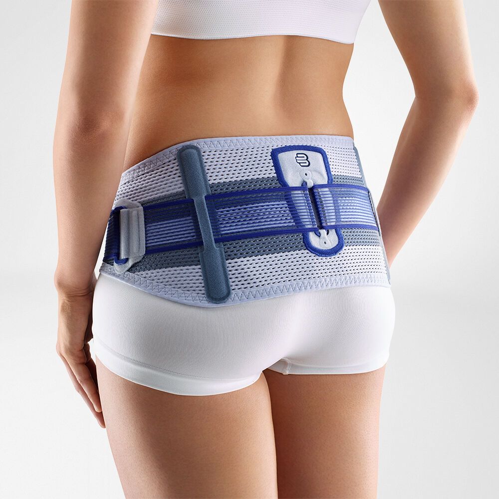 Rückansicht einer Frau mit SacroLoc titan Beckenorthese. Blau-graue Gurte, Klettverschluss und Logo sichtbar.