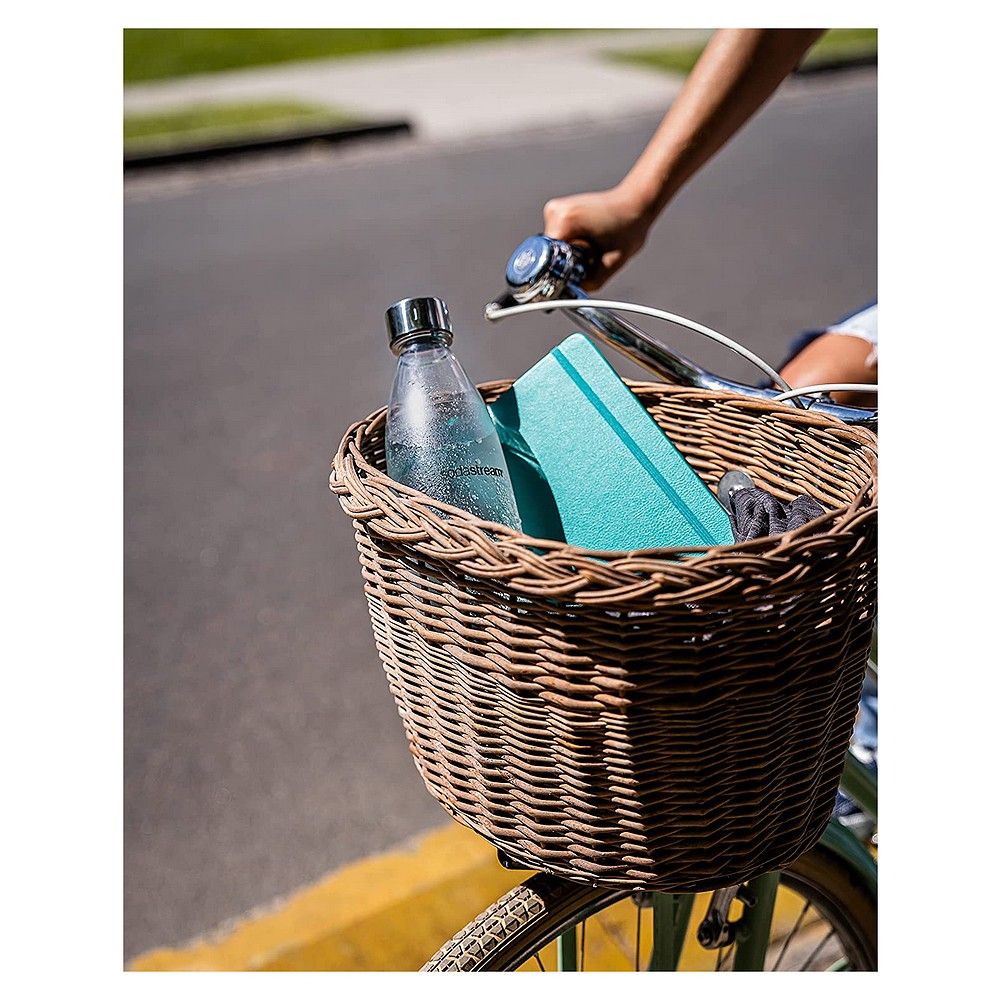 Sodastream PET-Flasche in einem Fahrradkorb neben einem Notizbuch.