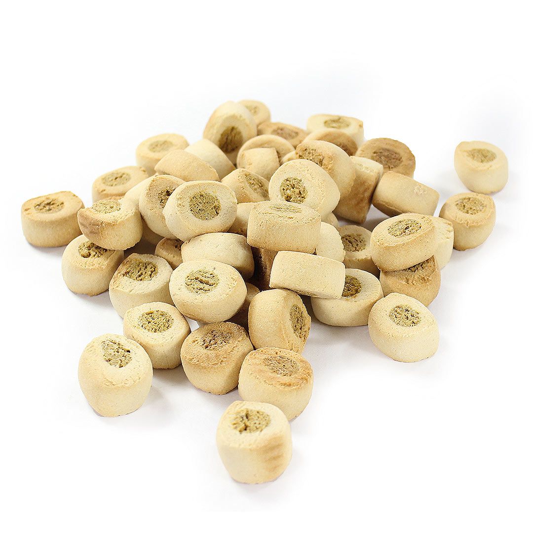 Hundekekse in runder Form mit hellem Teig und einer Füllung. Einzelne Kekse liegen auf weißem Untergrund.