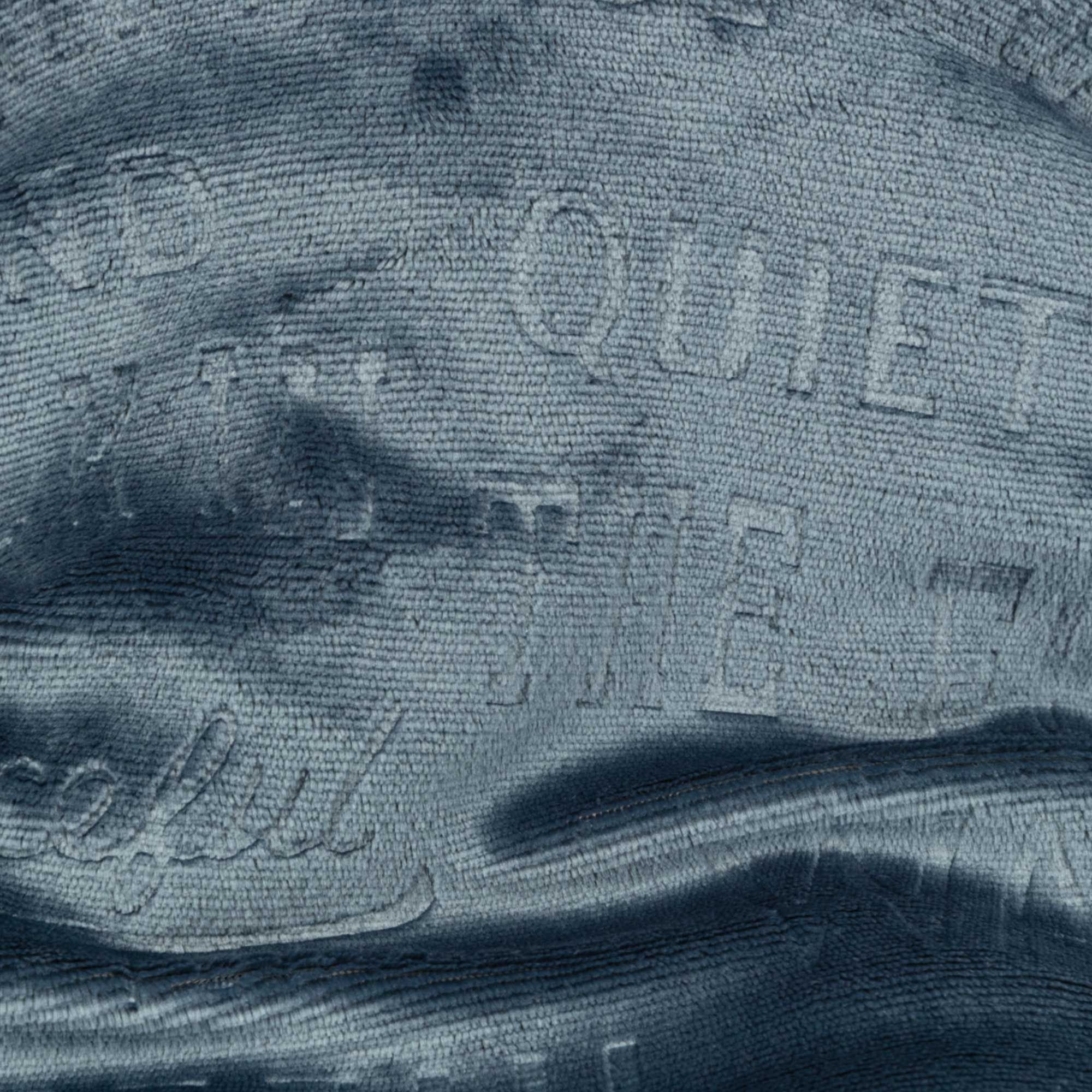 Nahaufnahme des blauen Kuschelsacks. Textmuster auf der Oberfläche.