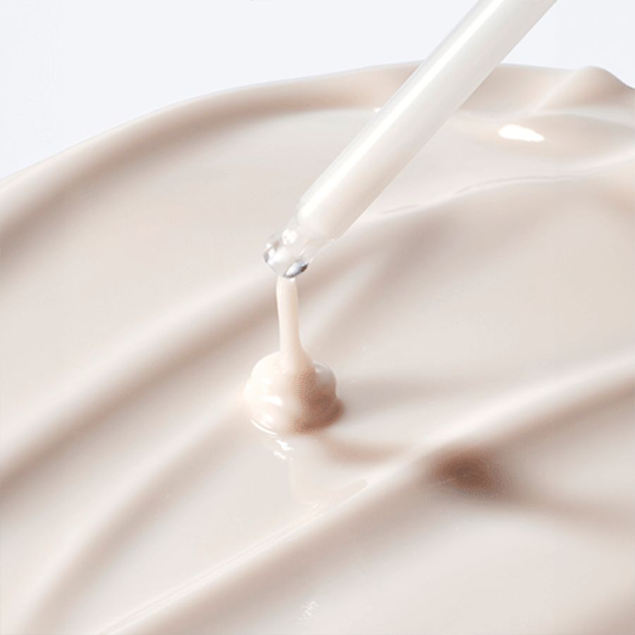 Nahaufnahme einer Creme mit Pipette. Creme-Textur, Tropfen fallen auf die Oberfläche.