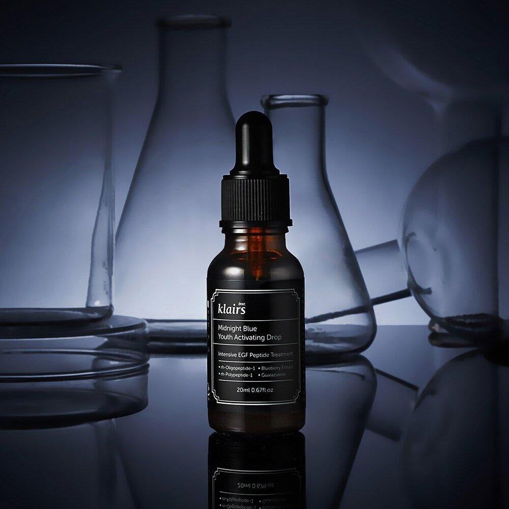 Braune Glasflasche mit schwarzem Deckel. Auf dem Etikett steht "Midnight Blue Youth Activating Drop".