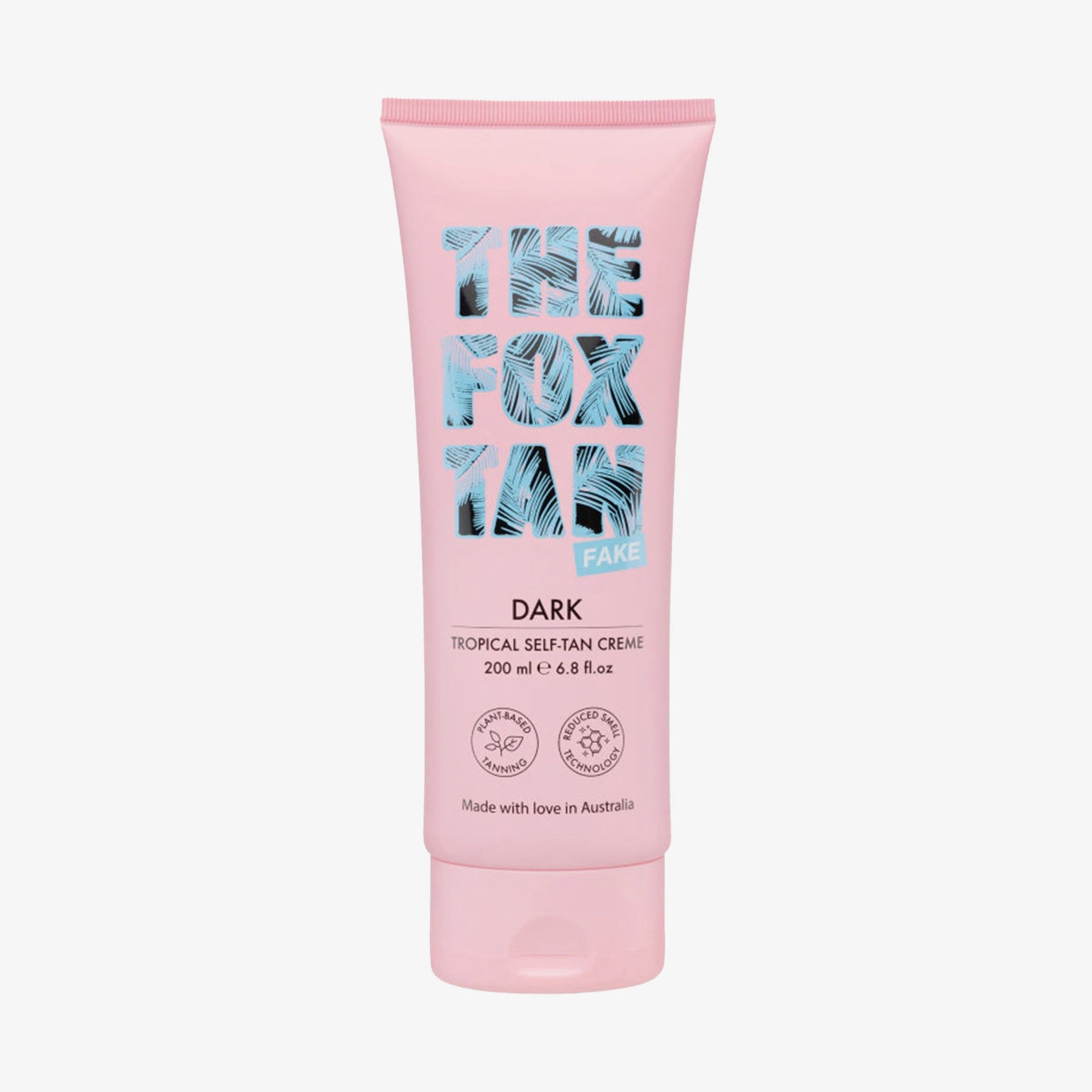 Rosa Tube mit blauem Logo und Text. "Dark Tropical Self-Tan Creme" und Zertifizierungen sind sichtbar.