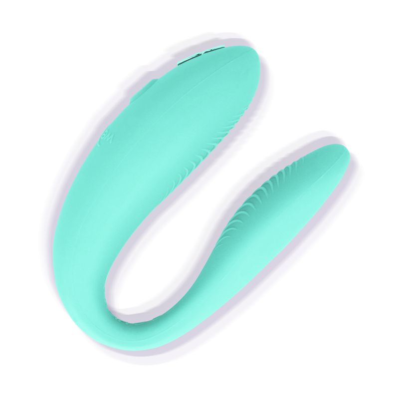 Türkisfarbener Vibrator. U-förmig mit geriffelter Oberfläche. Glatte, abgerundete Form.