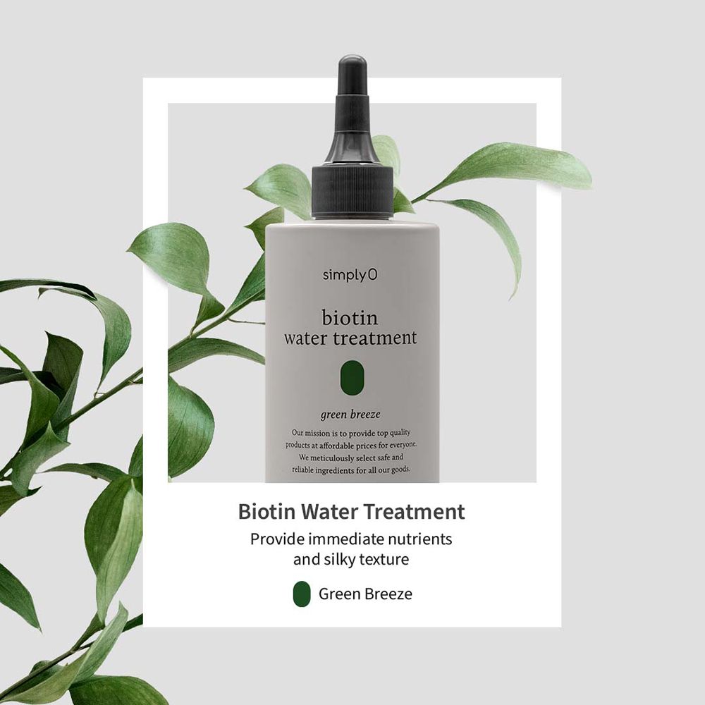 Graue Flasche mit schwarzem Applikator, umgeben von grünen Blättern. Aufschrift: SIMPLYO Biotin Water Treatment Green Breeze.