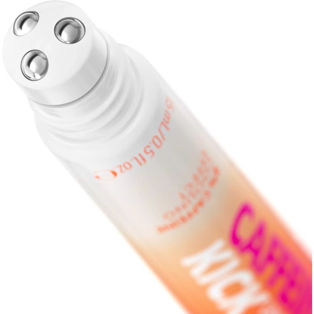 Nahaufnahme des Roll-on-Applikators. Drei Metallkugeln. Aufschrift: Caffeine Kick Under Eye Serum. Tube mit rosa-orangefarbenem Design.