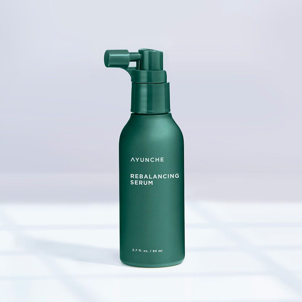 AYUNCHE Rebalancing Serum in dunkelgrüner Flasche mit Pumpspender, auf hellem Hintergrund.