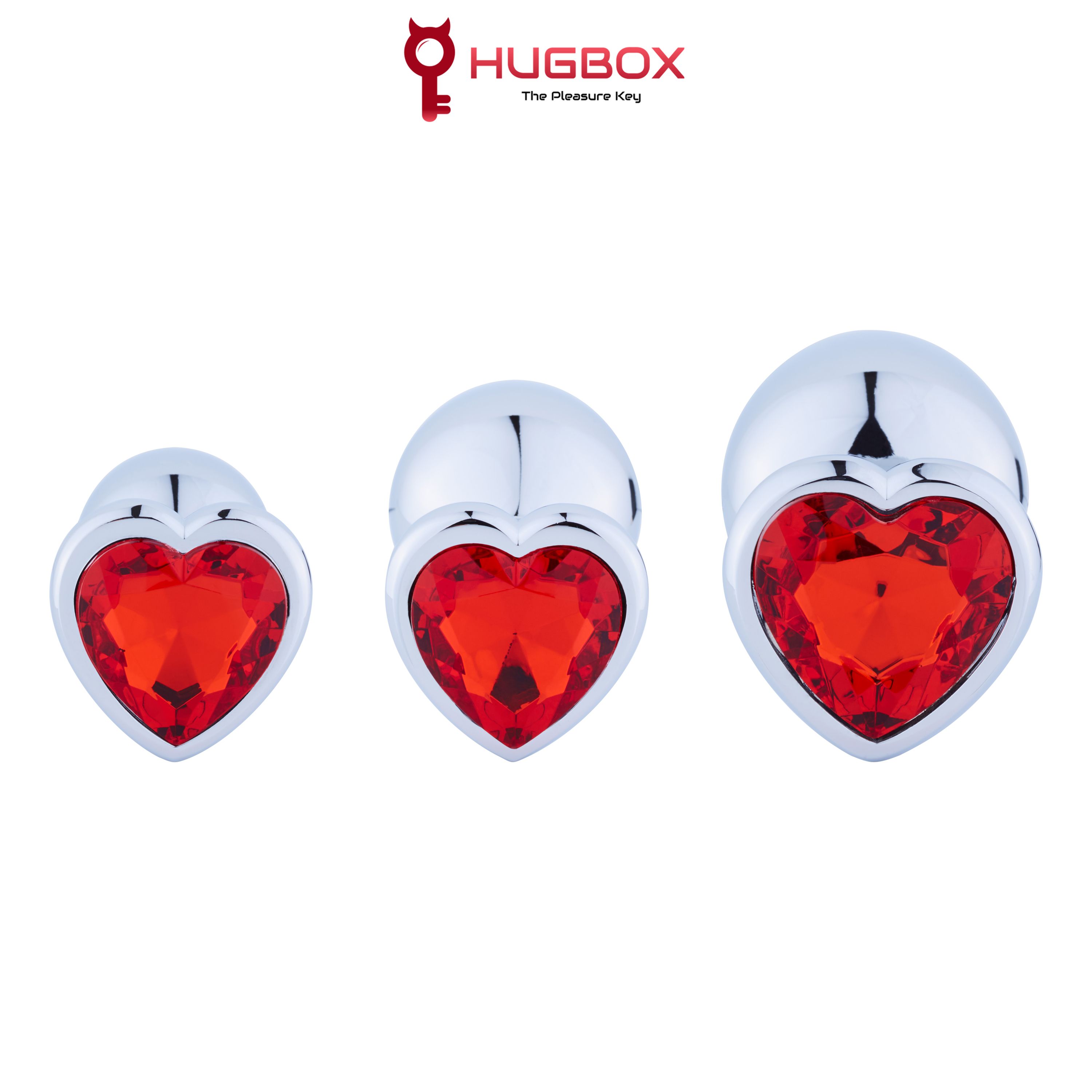 Drei Analplugs mit herzförmigen roten Kristallen. Unterschiedliche Größen, glänzende Oberfläche.