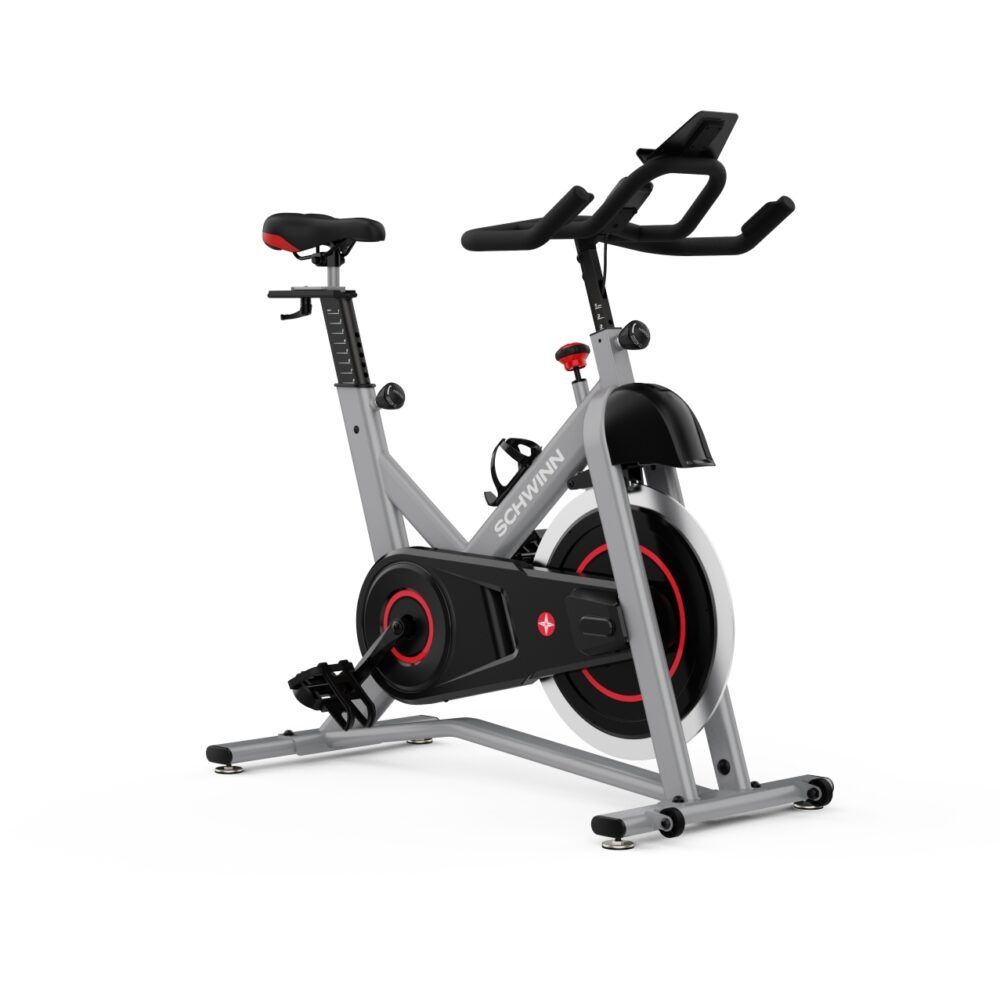 Graues Indoor-Cycle mit rotem Akzent. Sichtbar: Sattel, Lenker, Pedale, Schwungrad. Marke: Schwinn.