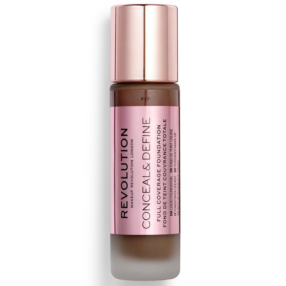 Foundation-Flasche mit roségoldfarbenem Deckel. Rosa Etikett mit Produktnamen und Marke. Dunkelbraune Foundation sichtbar.