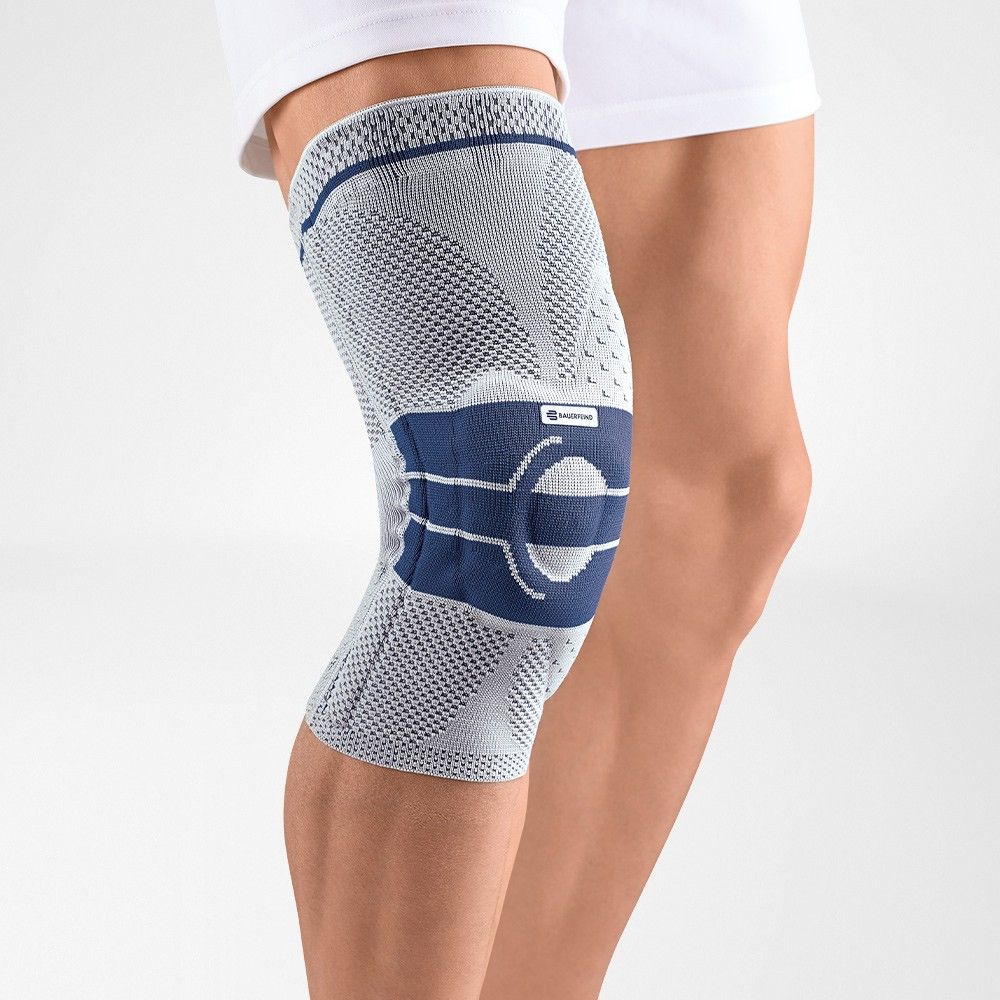 Kniebandage in Grau und Blau. Mesh-Material. Blaues Polster über der Kniescheibe. Bauerfeind-Logo.