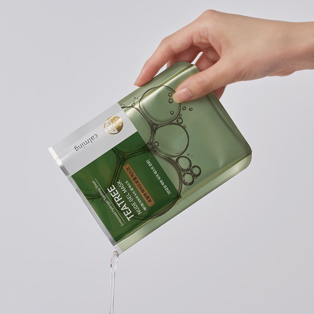 Hand hält die Verpackung der MEDIHEAL Teatree Nude Gel Hydrogelmaske, Flüssigkeit wird ausgegossen.