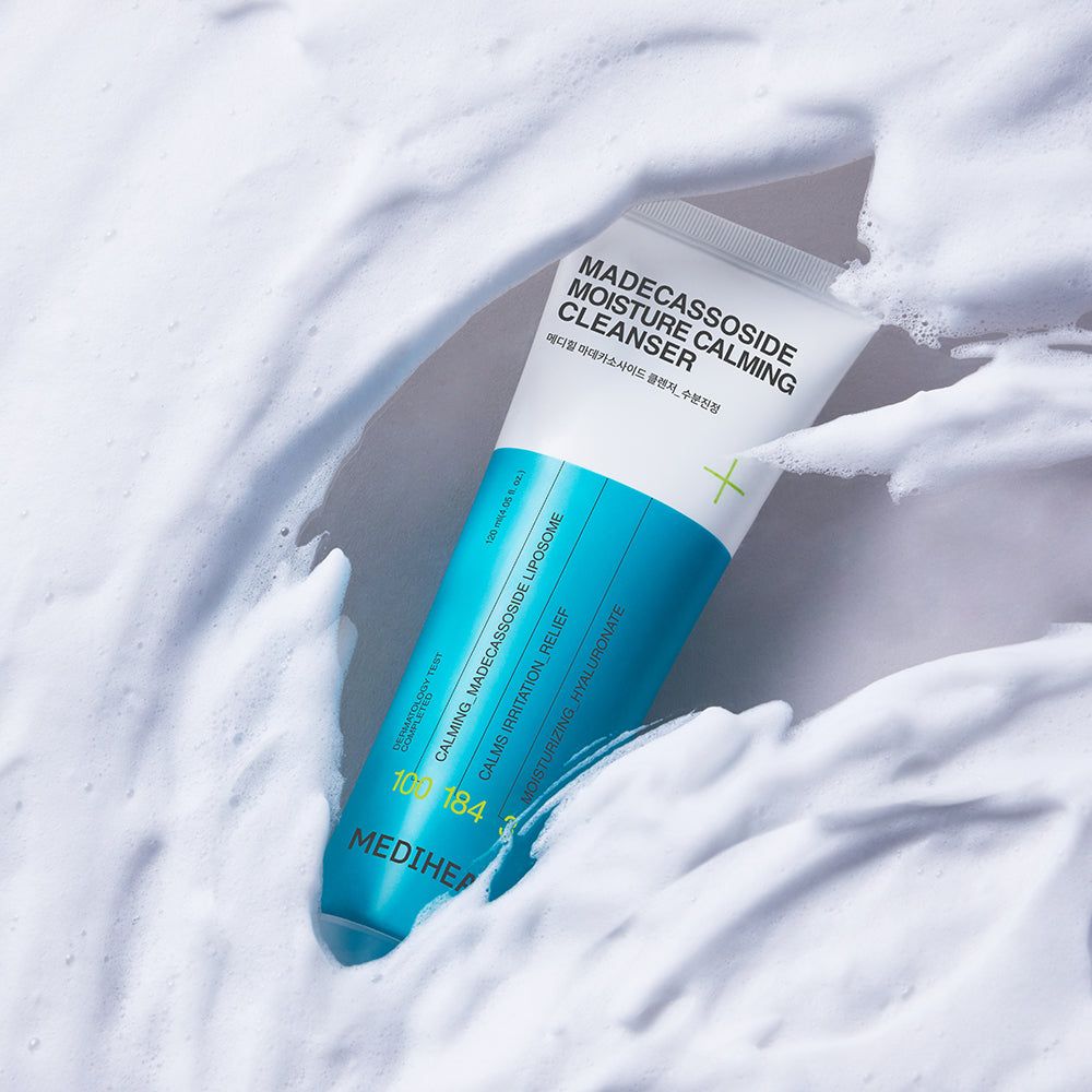 Weiß-blaue Tube in Schaum gebettet. Aufschrift: Madecassoside Moisture Calming Cleanser. Marke: MEDIHEAL. Text in Englisch und Koreanisch.